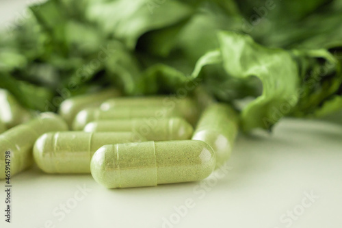 Herbal medicine capsules with Andrographis paniculata leaf on white background