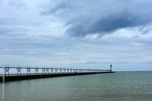 the historic manistee north pierhead lighthouse on fifth avenue beach on eastern lake michigan, michigan, with its elevated  walkway, on a stormy day photo