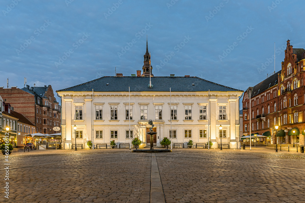 the town hall reflecting in the cobbled square at night
