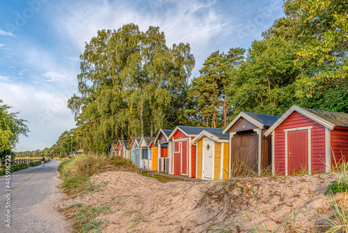 scenic beach huts in a row in the sand close to the sea photo