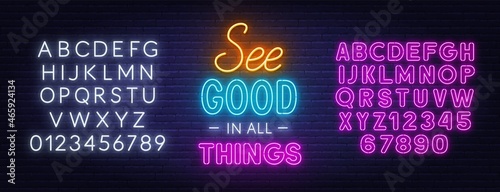 See Good in all Things neon lettering on brick wall background.