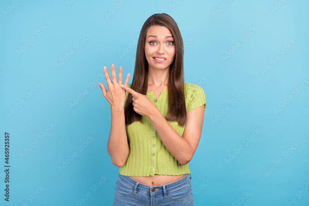 Photo of unhappy upset young woman point finger ring demant marrage isolated on blue color background Photo of unhappy upset young woman point finger ring demant marrage isolated on blue color background