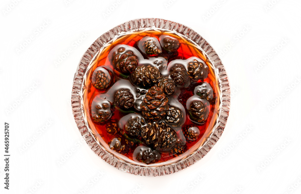 Young pine cones jam. Useful and tasty dessert. Traditional Siberian dessert - young pine cones jam. Glass ramekin of jam made from pine cones on a white background. on a white background Young pine cones jam. Useful and tasty dessert. Traditional Siberian dessert - young pine cones jam. Glass ramekin of jam made from pine cones on a white background. on a white background
