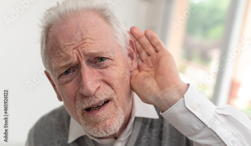 Senior man with hearing problems photo