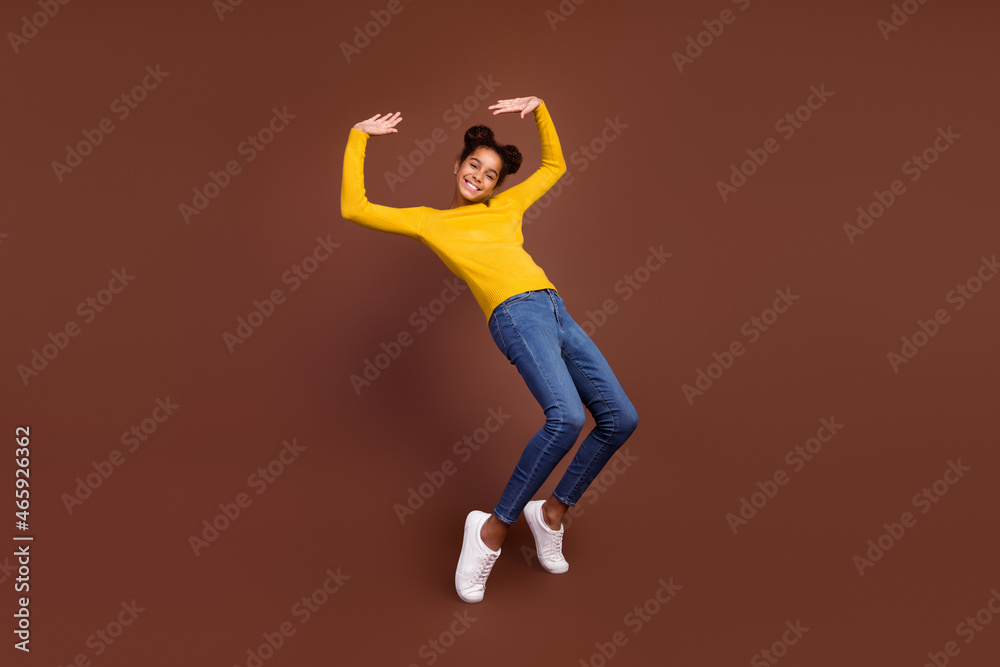 Full body photo of teen girl have fun wear jumper jeans footwear isolated on brown color background Full body photo of teen girl have fun wear jumper jeans footwear isolated on brown color background