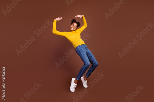 Full body photo of teen girl have fun wear jumper jeans footwear isolated on brown color background