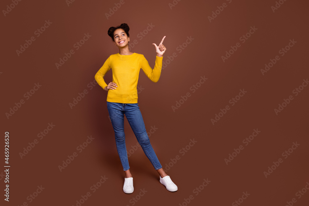 Full body photo of little girl index promo wear jumper jeans shoes isolated on brown color background Full body photo of little girl index promo wear jumper jeans shoes isolated on brown color background