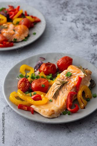 Baked red fish fillet Arctic char on a plates with vegetables close up, delicious hearty healthy dinner