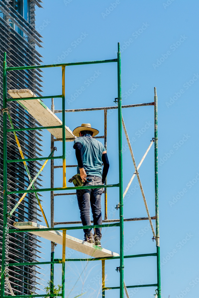Man working repairing high-rise building windows Man working repairing high-rise building windows