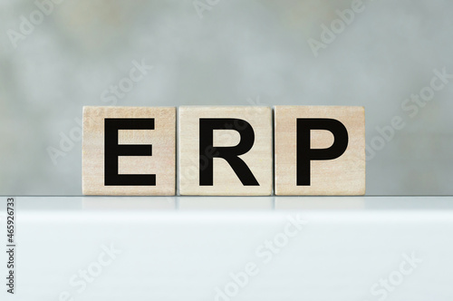 Three wooden cubes with letters ERP - stands for Enterprise Resource Planning on a light table
