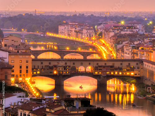 Ponte Vecchio at night with golden lights and Arno river