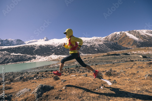 Woman trail runner in high altitude winter mountains