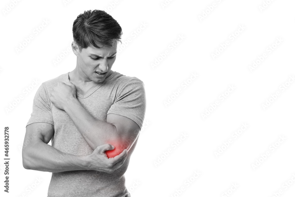 Disappoint young european man suffering from elbow pain, presses hand to sore spot, with red, monochrome Disappoint young european man suffering from elbow pain, presses hand to sore spot, with red, monochrome