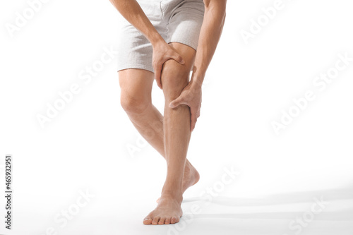 Canvas Print Unrecognizable millennial european man suffer from pain in knee and touching to