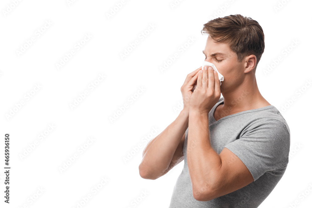 Millennial attractive caucasian guy suffering from first symptoms of flu and cold, runny nose, blows, feeling unwell Millennial attractive caucasian guy suffering from first symptoms of flu and cold, runny nose, blows, feeling unwell