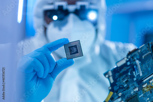 African-American scientist works in a modern scientific laboratory for the research and development of microelectronics and processors. Manufacturing worker uses computer technology and equipment. photo