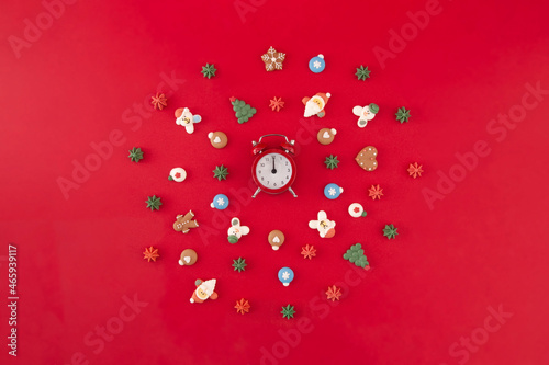 Christmas wreath of cookies with red o'clock on the red background. Time for Christmas. Christmas holiday creative concept.