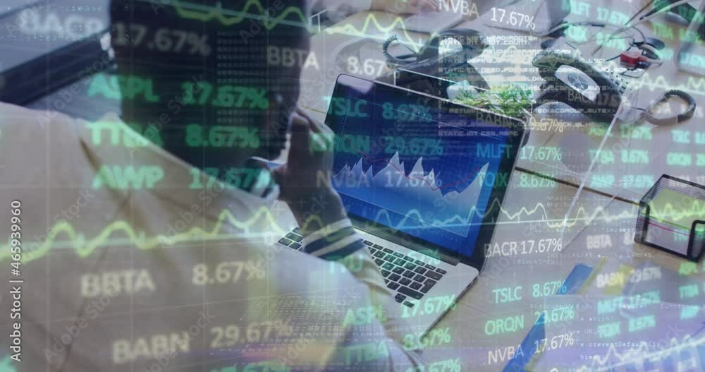 Animation of financial data processing over businessman with face mask using laptop in office Animation of financial data processing over businessman with face mask using laptop in office