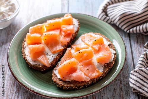 Healthy toasts with smoked salmon and cottage cheese on plate for breakfast
