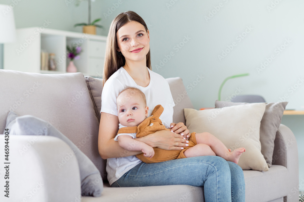 Photo of cheerful positive peaceful mother embrace little newborn baby boy wear white t-shirt home indoors Photo of cheerful positive peaceful mother embrace little newborn baby boy wear white t-shirt home indoors