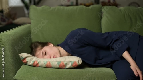 A tired woman after work in the office falls with a pillow on the sofa, she sleeps on the go. Slow motion of young woman falling on pillow