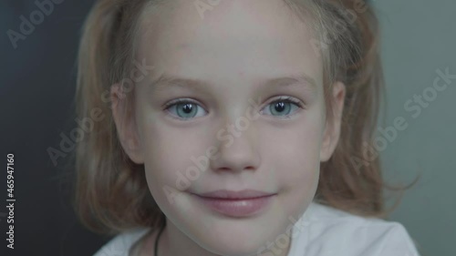 Cute little girl kid looking at camera. Portrait of young female child with big blue eyes. Concept of children and kids 