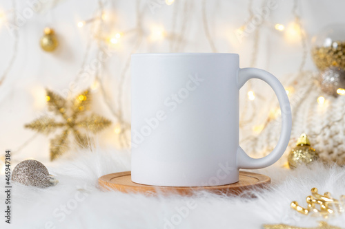 Imprint mockup white ceramic coffee mug on cozy Christmas background with copy space for your design. Standard 11 oz mug for branding and souvenirs