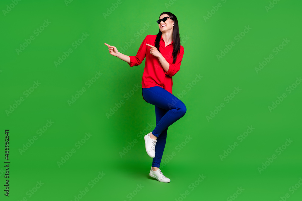 Full length body size view of attractive lucky cheerful lady demonstrating copy space ad solution isolated over bright green color background Full length body size view of attractive lucky cheerful lady demonstrating copy space ad solution isolated over bright green color background