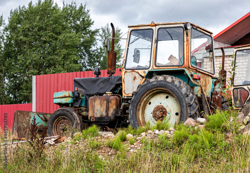 Old rusty wheeled tractor at the village Old rusty wheeled tractor at the village