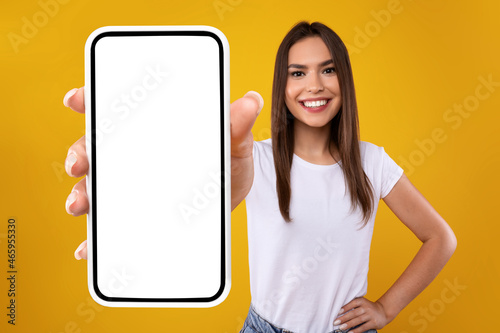 Woman showing white empty smartphone screen close to camera