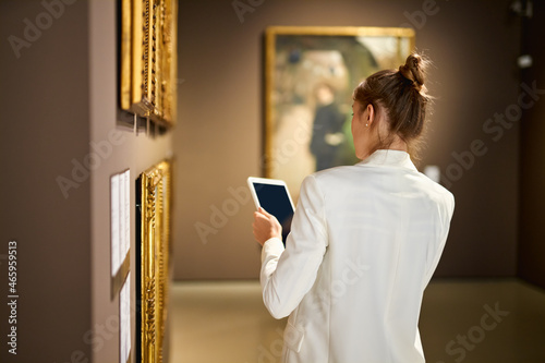 Woman visitor in the historical museum looking at pictures