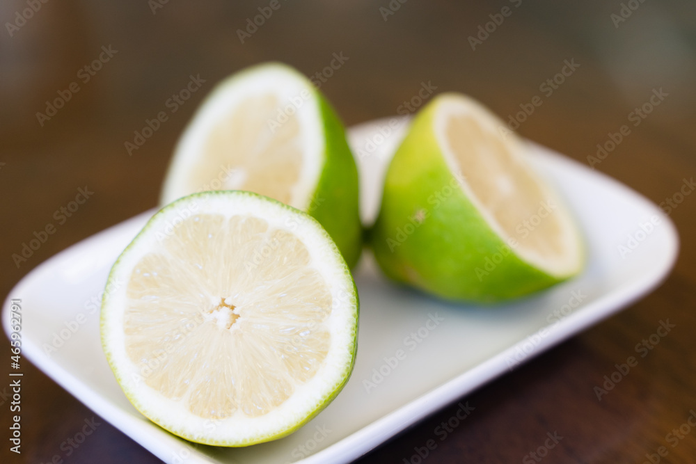Closeup on lime halves on small plate. Green lemon slices Closeup on lime halves on small plate. Green lemon slices