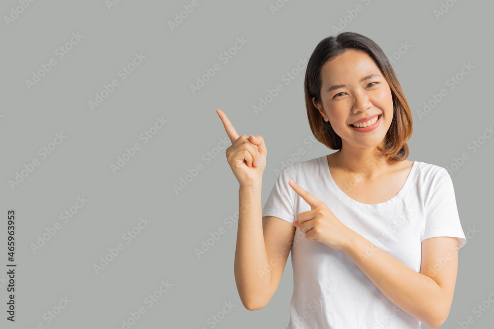 close up young beautiful asian woman smile and hand pointing isolated on gray background for business maketing and advertisement promotion concept close up young beautiful asian woman smile and hand pointing isolated on gray background for business maketing and advertisement promotion concept