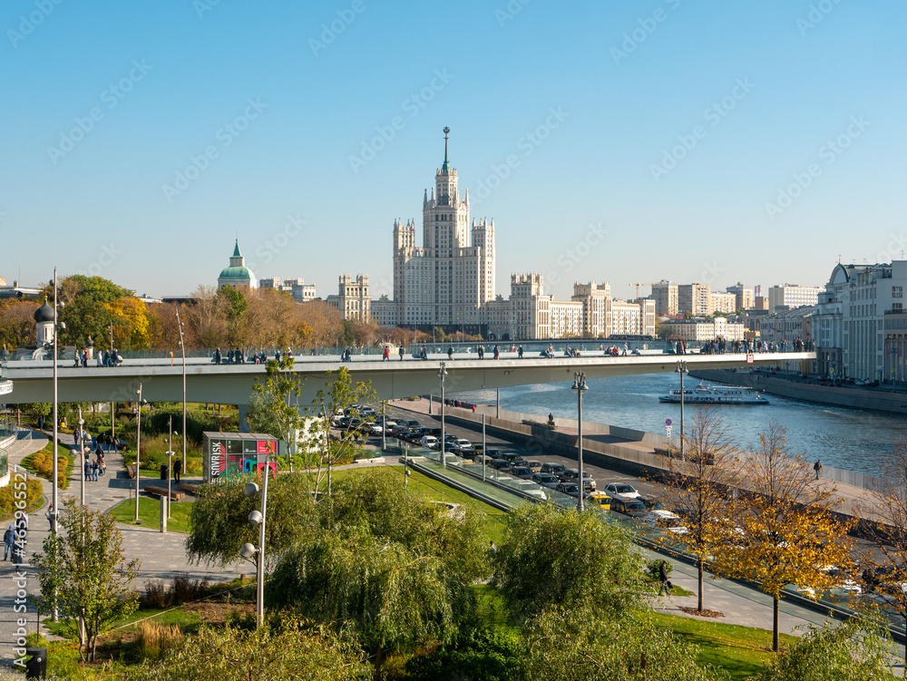 Naklejka premium Moscow, Russia - October 5, 2021: Zaryadye Park. Floating bridge with walking people against the background of the Moscow river and the architecture of the city