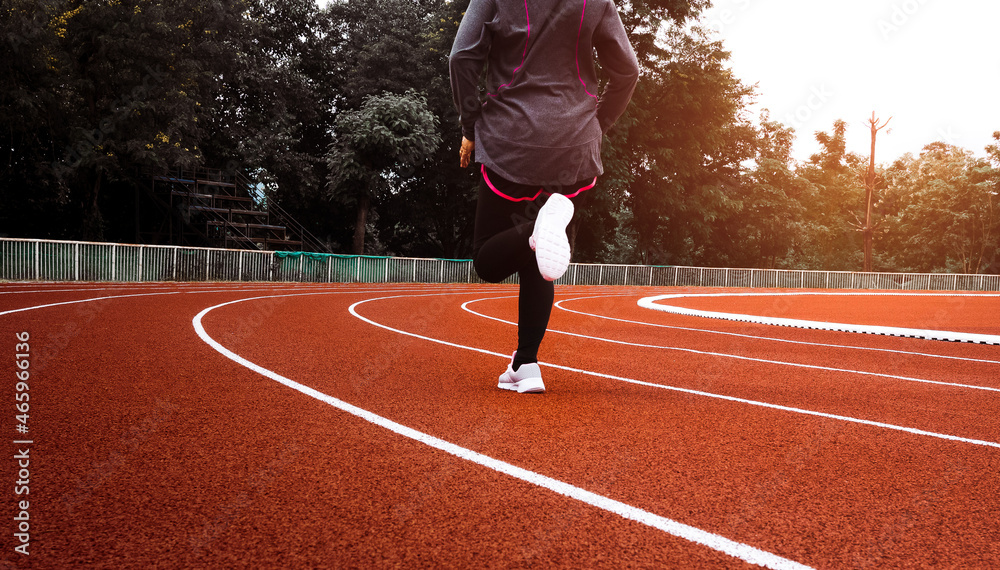 Athletic woman in sport clothes running on stadium track. Female runner jogging for exercise. Workout Healthy lifestyle concept. Athletic woman in sport clothes running on stadium track. Female runner jogging for exercise. Workout Healthy lifestyle concept.