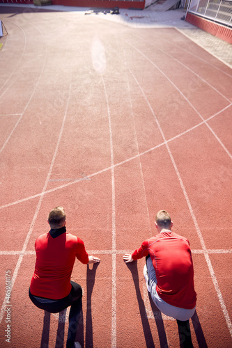  Conceptual image of competition. Two caucasian men at starting line of athletic track ready to start the race. © luckybusiness