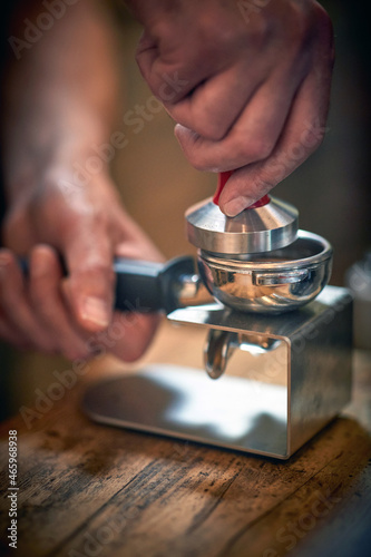 Close-up view of a barman's hands preparing an espresso. Coffee, beverage, bar