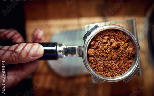 Close-up of an utensil full of ground coffee ready for making an espresso. Coffee, beverage, bar
