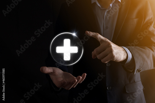 Businessman hold virtual plus medical network connection icons. Covid-19 pandemic develop people awareness and spread attention on their healthcare.