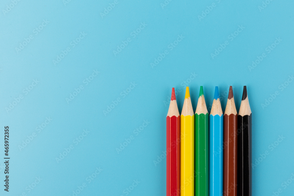 Six colored pencils close-up on a blue background with a copy of the space. The texture of bright colored wooden pencils. Six colored pencils close-up on a blue background with a copy of the space. The texture of bright colored wooden pencils.