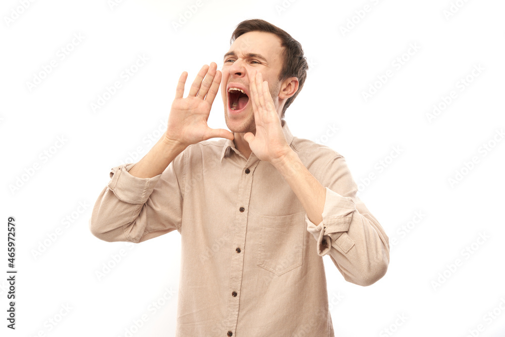 Handsome happy young caucasian male shouting and cupping hands around mouth isolated on white studio background. Excited news attention! Handsome happy young caucasian male shouting and cupping hands around mouth isolated on white studio background. Excited news attention!