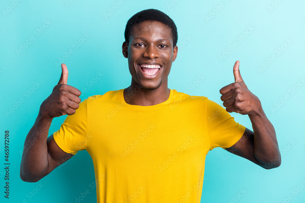 Photo of crazy brunette hairdo millennial man show thumb up wear yellow t-shirt isolated on cyan color background