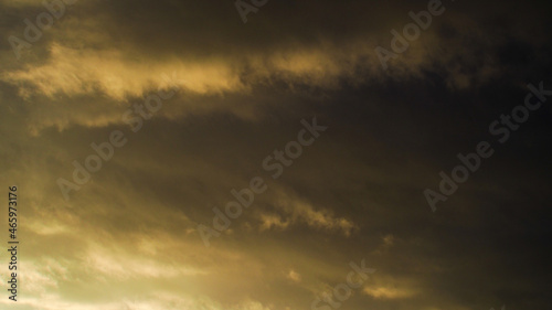 Reflets jaunâtres sous un cumulonimbus illuminé par le soleil couchant, dont les rayons s'infiltrent par sa base. Cet orage est en phase de dissipation © Anthony