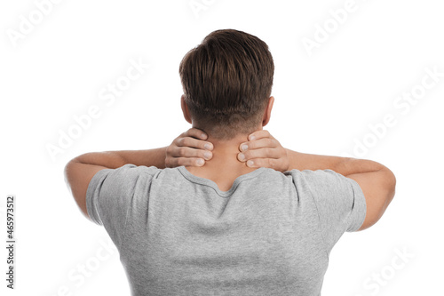 Millennial caucasian guy suffering from neck pain, presses his hand to sore spot © Prostock-studio