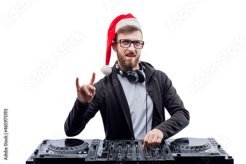 Funny dj guy in Santa's hat, glasses plays music on a turntable while gesturing rock sign
