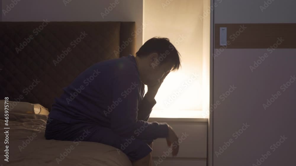Depressed lonely elderly old Asian woman, people sitting on bed in bedroom at home. Lifestyle on late night. Insomnia. Quarantine Depressed lonely elderly old Asian woman, people sitting on bed in bedroom at home. Lifestyle on late night. Insomnia. Quarantine