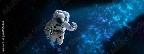 Fototapeta Naklejka Na Ścianę i Meble -  Astronaut in outer,open space , which is behind. Blue beautiful nebula.Elements of this image furnished by NASA.