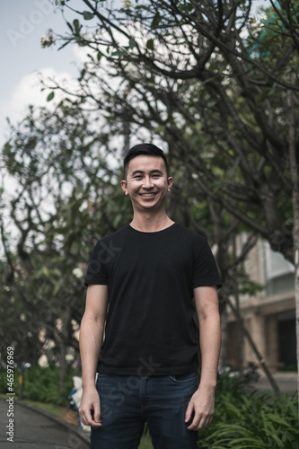 Portrait of asian young handsome man in casual clothing standing on the street and smiling. Asia, Chinese people, real life concept, sunny day
