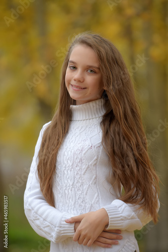 girl brunette child in white sweater in autumn in the park © Evdoha