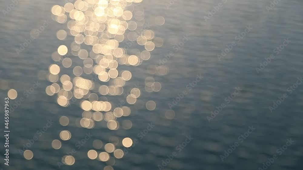 Abstract motion of the sunset sea, shimmering water defocused background, bokeh effect